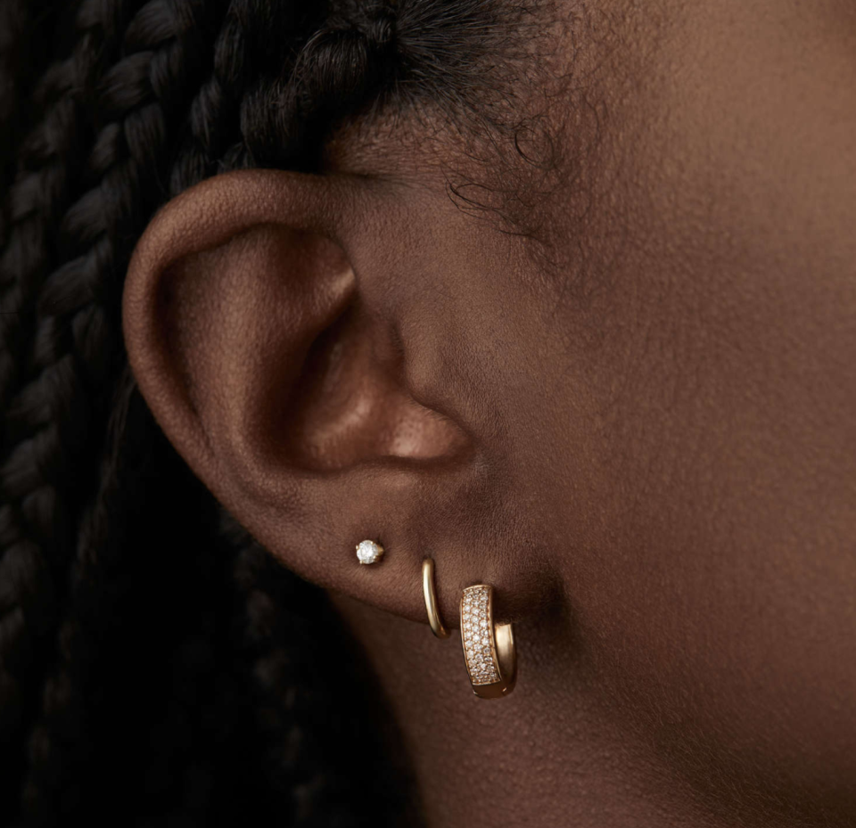 black model close up wearing three earrings mejuri Pavé Diamond Bold Hoops 