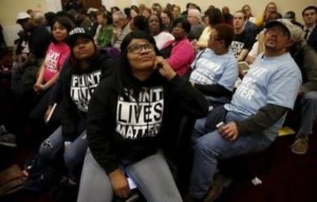 Sitting in an overflow room, Flint, Michigan residents watch a live video feed as Michigan Governor Rick Snyder and EPA Administrator Gina McCarthy testify before a House Oversight and government Reform hearing on "Examining Federal Administration of the Safe Drinking Water Act in Flint, Michigan, Part III" on Capitol Hill in Washington March 17, 2016. REUTERS/Kevin Lamarque