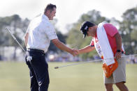 Jason Kokrak, left, shakes hands with his caddie David Robinson, right, after sinking the last putt on the 18th green to win the Houston Open golf tournament with ten under par Sunday, Nov. 14, 2021, in Houston. (AP Photo/Michael Wyke)