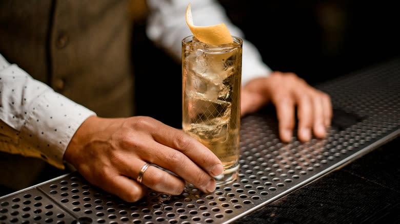 Bartender holding whiskey tonic