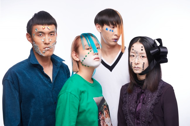 A group of people wearing makeup with jewels and shapes stuck to your face.