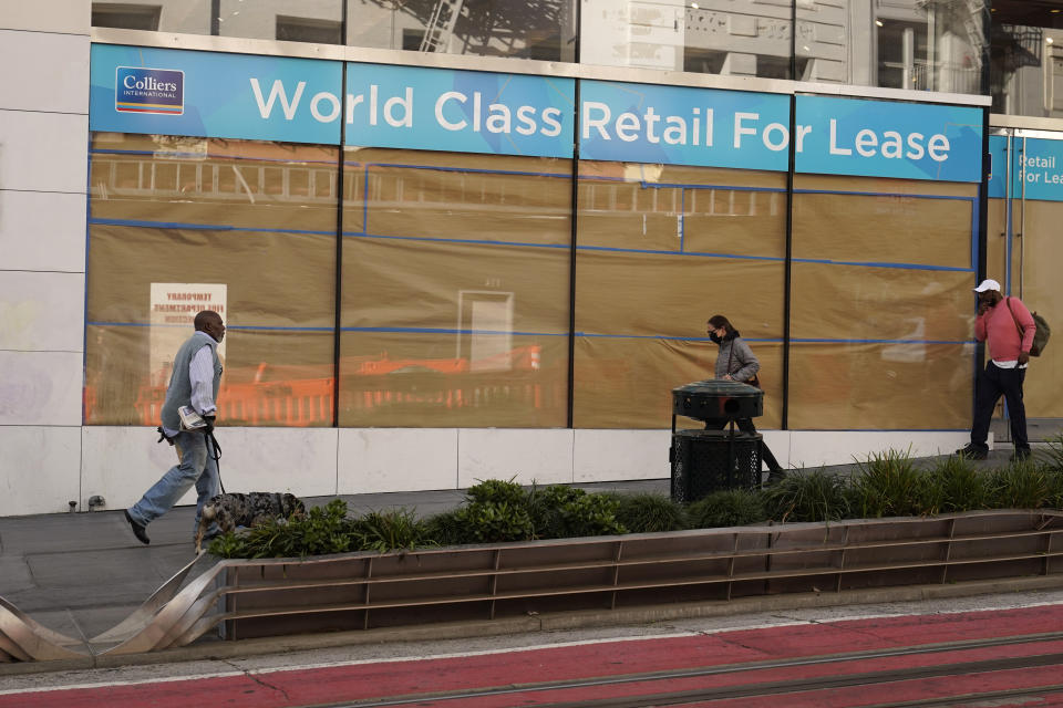 People walk past a large retail space for lease at Union Square in San Francisco, Thursday, Dec. 2, 2021. In San Francisco, homeless tents, open drug use, home break-ins and dirty streets have proliferated during the pandemic. The quality of life crimes and a laissez-faire approach by officials to brazen drug dealing have given residents a sense the city is in decline. (AP Photo/Eric Risberg)