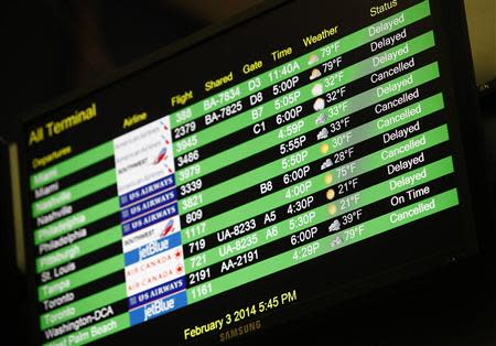A departure monitor shows cancelled and delayed flights in terminal C at LaGuardia Airport in the Queens borough of New York February 3, 2014. REUTERS/Joshua Lott