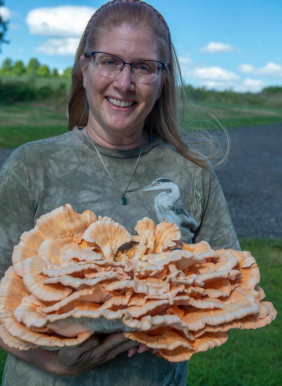 Rachel Goclawski holds a chicken in the woods mushroom at the Shaw Farm in Sutton, Aug. 31, 2022. 