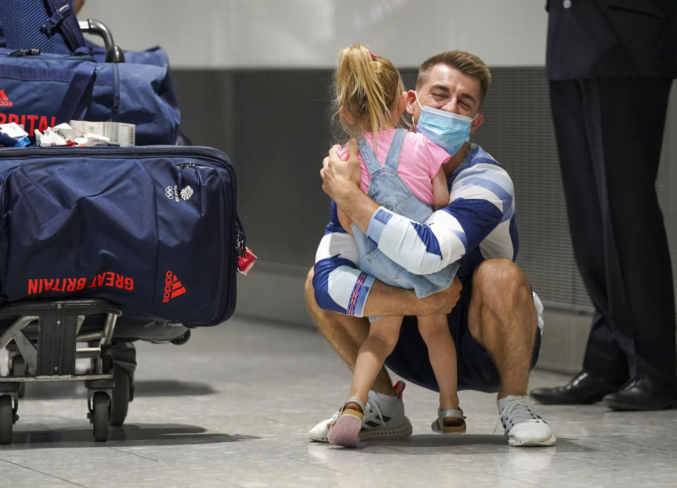 Olympic gymnast Max Whitlock hugs his daughter as he arrives back at London Heathrow Airport from the Tokyo 2020 Olympic Games. Picture date: Tuesday August 3, 2021.