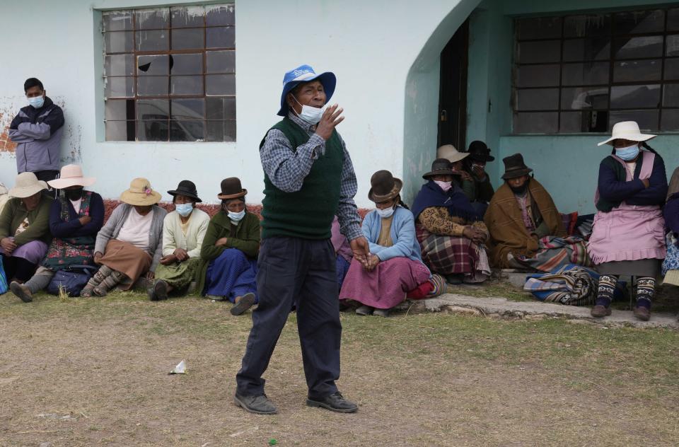 A resident explains his reasons for not getting a COVID-19 vaccine at a school being used as a vaccination site where shots of Sinopharm are administered in Mijane, Peru, Thursday, Oct. 28, 2021. Doubts to get vaccinated are common among Peru's Indigenous people, who make up about a quarter of the country's 33 million people — and they have complicated the national vaccination drive. (AP Photo/Martin Mejia)