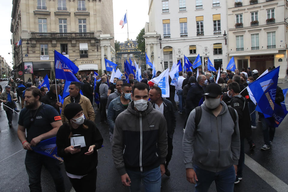 ADDS AN UPDATE FROM THE FRENCH GOVERNMENT - FILE - In this June 12, 2020, file photo, French police unionists demonstrate in front of the Interior Ministry in Paris. France's government is testing stun guns for wider use after announcing a ban on police chokeholds. French police staged protests around the country last week, after the ban on the immobilization tactic that led to the death of George Floyd in the U.S. The French government later backed away from a complete chokehold ban. (AP Photo/Michel Euler, File)