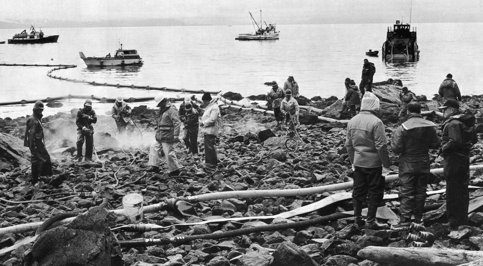 FILE - Workers test a mild chemical oil dispersant on a beach contaminated by the Exxon spill in Anchorage, Alaska, on May 18, 1989. Joseph Hazelwood, the captain of the Exxon Valdez oil tanker that ran aground more than three decades ago in Alaska, causing one of the worst oil spills in U.S. history, has died, the New York Times reported. He was 75. He died in July 2022, after struggling with COVID-19 and cancer, his nephew Sam Hazelwood told the newspaper for a story reported Friday, Sept. 9, 2022. (AP Photo/Clare Richardson, File)