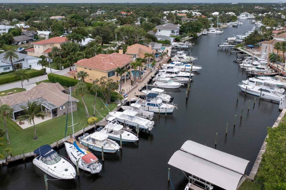 Multiple boats are docked beside homes in the Paradise Port community in Palm Beach Gardens on June 7.