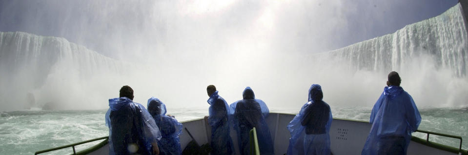 FILE - In this April 21, 2005 file photo, a group of tourists brave opening day on the bow of the Maid of the Mist at the base of the Horseshoe Falls, from Niagara Falls, N.Y. In recent years, for economic reasons, Niagara Falls has thrown open its doors to casino gambling, gay weddings and a tightrope walk that, until laws were relaxed, would have meant arrest. It even briefly considered taking in toxic wastewater from hydraulic fracturing. On the drawing board now is a plan to entice young people to move in by paying down their student loans. (AP Photo/David Duprey, file)