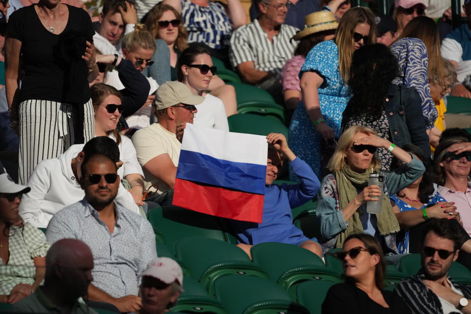 FILE - A spectator holding a Russian flag watches during the men's singles third round match between Russia's Daniil Medvedev and Croatia's Marin Cilic on day six of the Wimbledon Tennis Championships in London, Saturday July 3, 2021. The ATP men’s professional tennis tour will not award ranking points for Wimbledon this year because of the All England Club’s ban on players from Russia and Belarus over the invasion of Ukraine. The ATP announced its decision Friday night, May 20, 2022, two days before the start of the French Open — and a little more than a month before play begins at Wimbledon on June 27. It is a highly unusual and significant rebuke of the oldest Grand Slam tournament. (AP Photo/Alberto Pezzali, File)