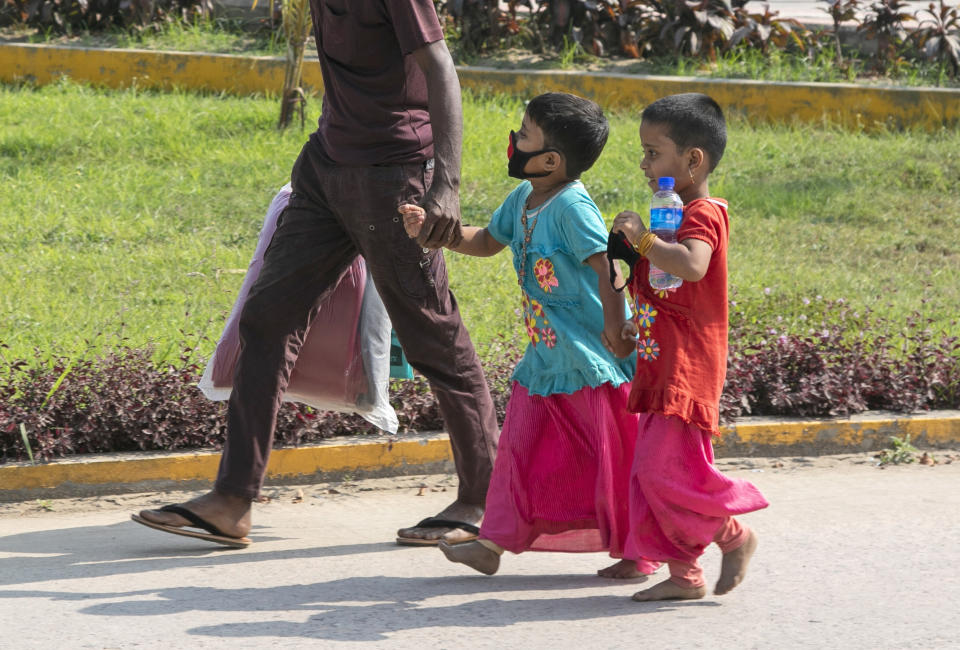 Rohingya refugee children arrive with an adult to board a naval vessel that will take them to Bhasan Char island, in Chittagong, Bangladesh, Thursday, Nov. 25, 2012. Thousands have been relocated on the island in the Bay of Bengal from crammed camps near the Myanmar border. (AP Photo)