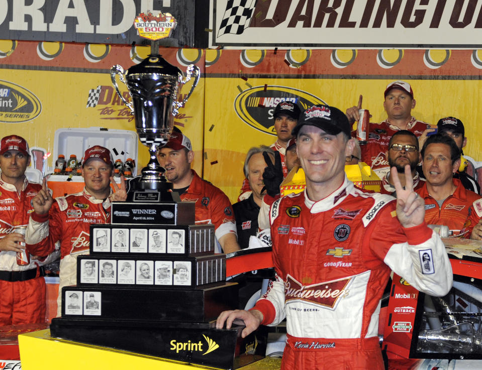 Kevin Harvick poses with the trophy in Victory Lane after winning the NASCAR Sprint Cup series auto race at Darlington Raceway in Darlington, S.C., Saturday, April 12, 2014. (AP Photo/Mike McCarn)