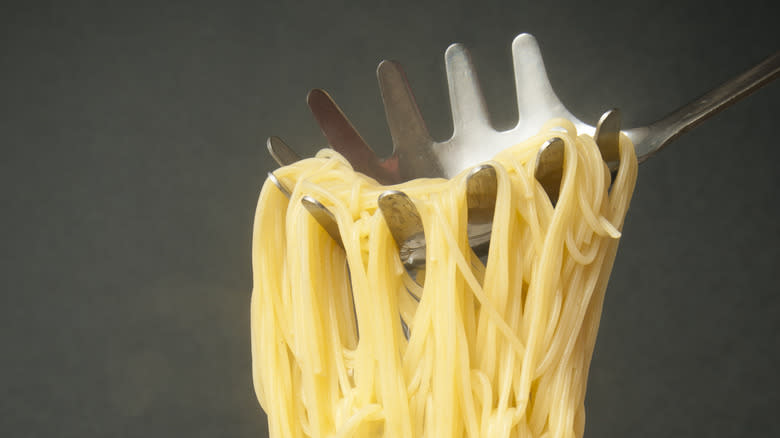 pulling angel hair pasta out of boiling water