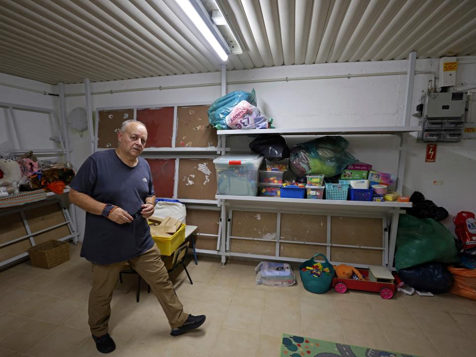 A man walks through a furnished shelter containing children's toys and emergency supplies in Israel.