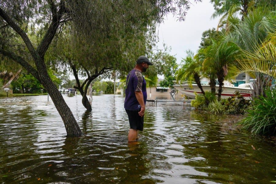 Chad Hinchman, 40, looks around his flooded front yard in Pasadena, Fla., as Hurricane Idalia makes landfall in the Big Bend region, Wednesday, Aug. 30, 2023. (Martha Asencio-Rhine/Tampa Bay Times via AP)