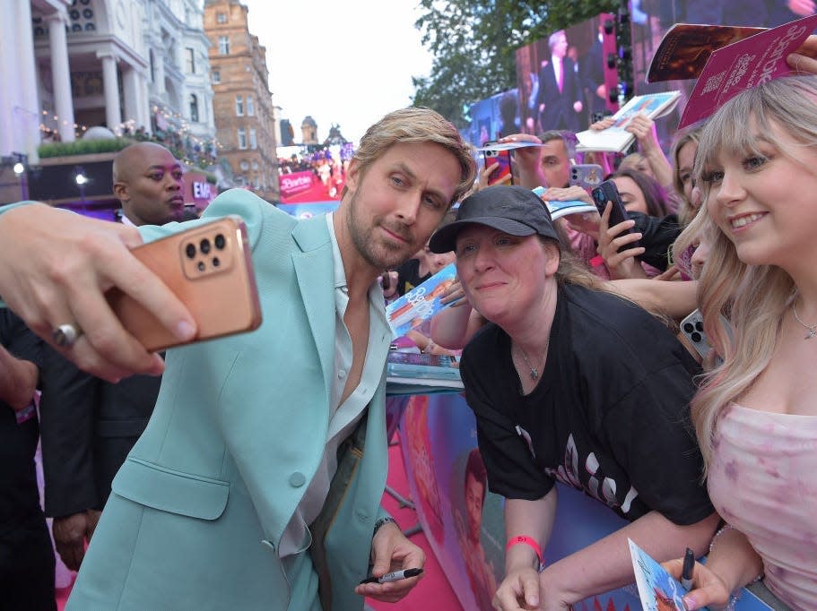 Ryan Gosling poses with fans at "Barbie" event
