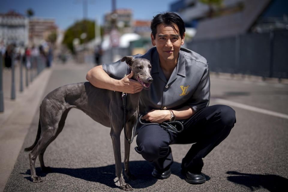Eddie Peng poses with his dog Xin during an interview for the film 'Black Dog' at the 77th international film festival, Cannes, southern France, Tuesday, May 21, 2024. (Photo by Andreea Alexandru/Invision/AP)