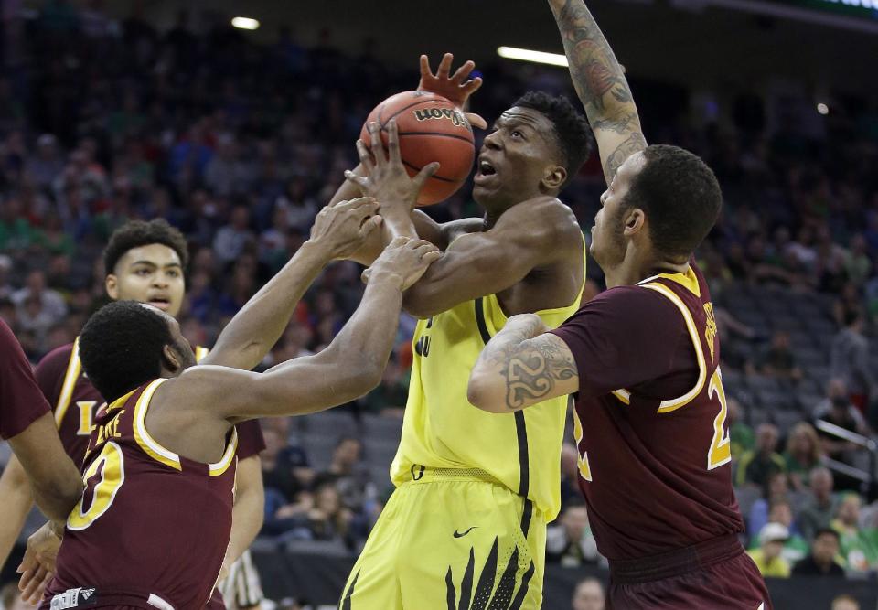 Oregon forward Kavell Bigby-Williams, center, is fouled by Iona guard Jon Severe, left, during the first half of a first-round game in the men's NCAA college basketball tournament Sacramento, Calif. Friday, March 17, 2017. (AP Photo/Rich Pedroncelli)