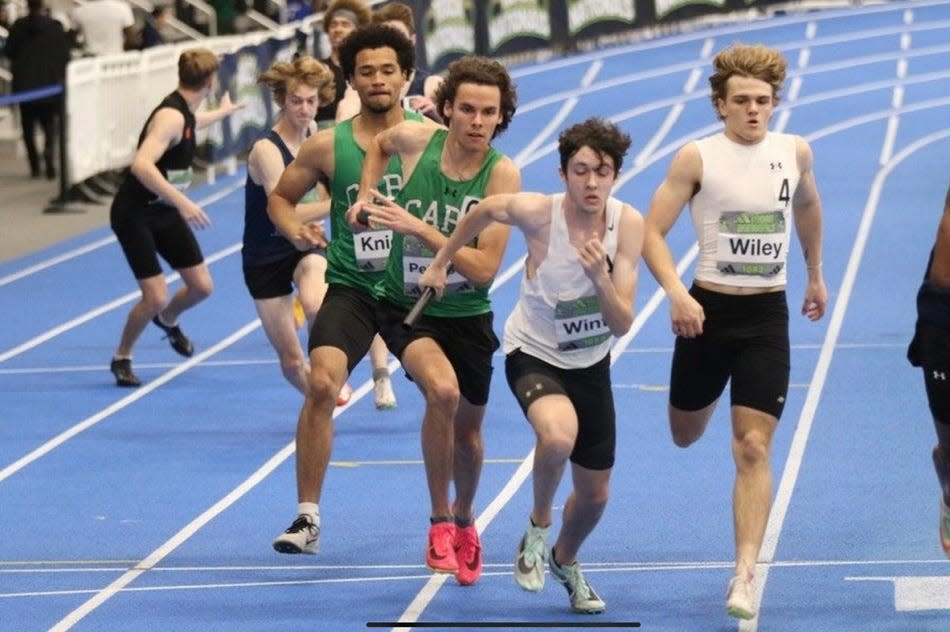 Iona Prep's Peter Winter takes off with the baton after getting it from Landen Wiley during the boys 1,600-meter sprint medley relay at the 2024 Adidas Indoor Nationals in Virginia. Iona Prep won the championship.
