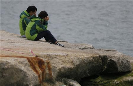 Family members of missing passengers on the capsized South Korean ferry Sewol cry as they look out to the sea at a port in Jindo, where family members of missing passengers gathered, April 22, 2014. REUTERS/Issei Kato