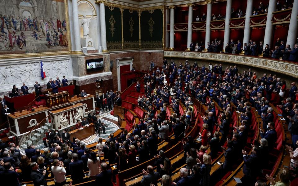 French lawmakers applaud as Ukrainian President Volodymyr Zelensky appears on a screen to address them via video link, amid Russia's invasion of Ukraine, at the National Assembly in Paris, France on March 23, 2022.  - Benoit Tessier/Reuters