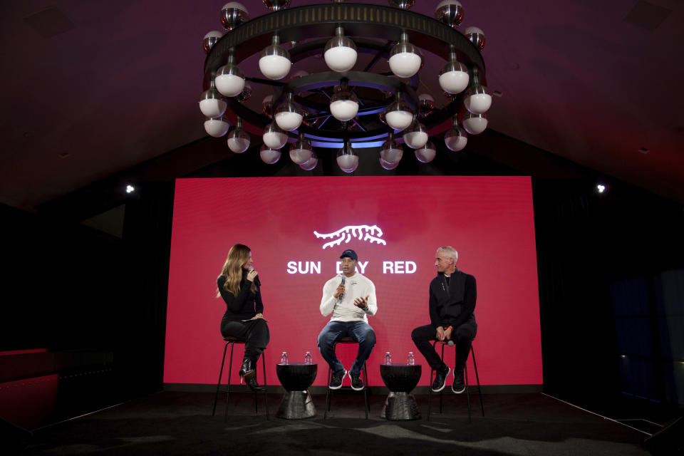 Tiger Woods, center, speaks as Erin Andrews, left, and David Abeles, right, CEO and president at TaylorMade, listen during news conference ahead of the Genesis Open golf tournament, Monday, Feb. 12, 2024, in the Pacific Palisades area of Los Angeles. (AP Photo/Eric Thayer)