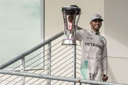 Oct 23, 2016; Austin, TX, USA; Mercedes driver Lewis Hamilton (44) of Great Britain holds up the trophy for the crowd after he wins the United States Grand Prix at the Circuit of the Americas. Jerome Miron-USA TODAY Sports