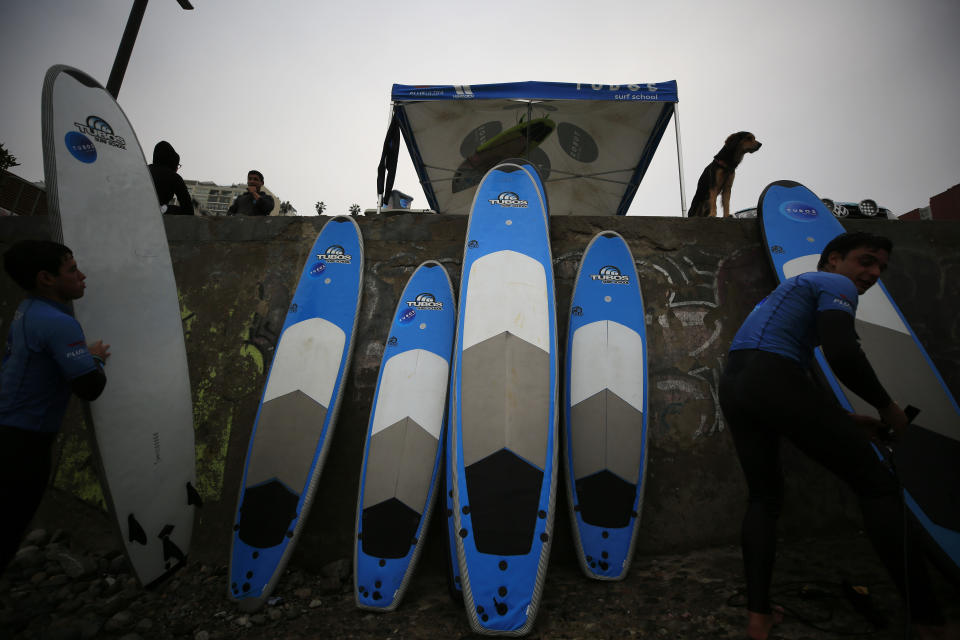 Surf instructors line up boards against a wall, after a surf lesson at Barranquito beach in Lima, Peru, Thursday, July 25, 2019. Today, dozens of schools teach locals and tourists from across the world how to ride waves at beaches with Hawaiian names in Lima's Miraflores district, while professional surfers from across the Americas prepare to compete when the sport is featured for the first time in the Pan American Games in the Peruvian capital.(AP Photo/Rebecca Blackwell)