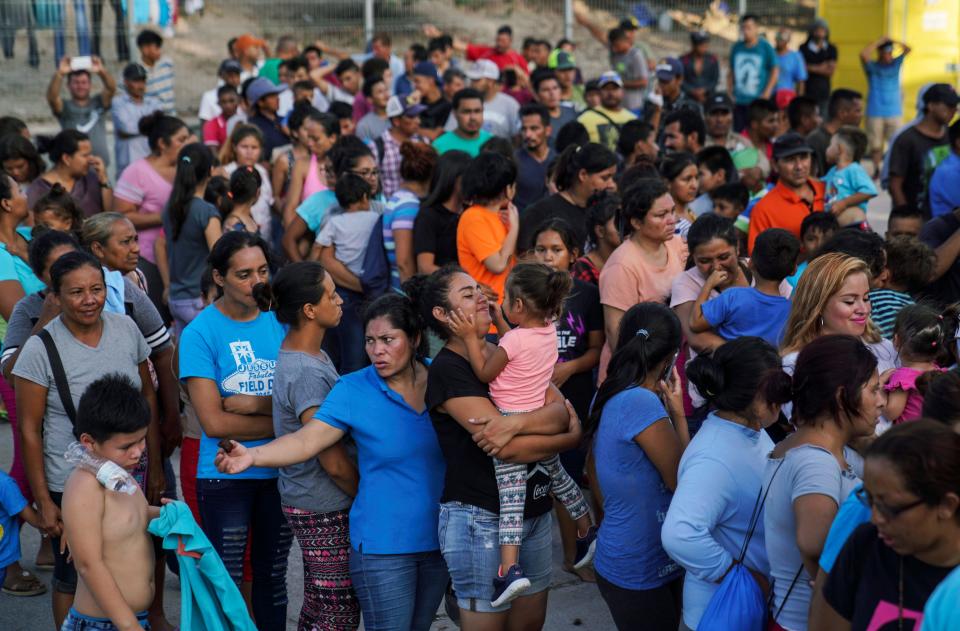 On Aug. 30, 2019, migrants, many who were returned to Mexico under the Trump administration's "Remain in Mexico" program, wait in line to get a meal in an encampment near the Gateway International Bridge in Matamoros, Mexico.