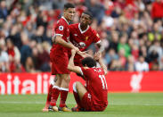 <p>Liverpool’s Philippe Coutinho and Georginio Wijnaldum help Mohamed Salah up</p>