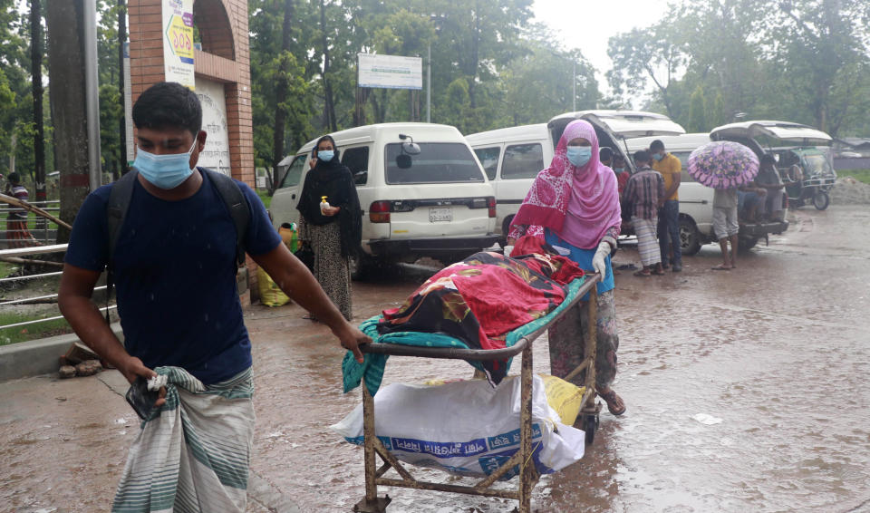 People leave for home with body of a relative at the Medical College Hospital in Rajshahi, 254 kilometers (158 miles) north of the capital, Dhaka, Bangladesh, June 15, 2021. Rajshahi has become one of the latest hotspots for the deadlier delta variant of the coronavirus. Bangladeshi authorities are increasingly becoming worried over the quick spread of coronavirus in about two dozen border districts close to India amid concern that the virus could devastate the crowded nation in coming weeks. (AP Photo/Kabir Tuhin)