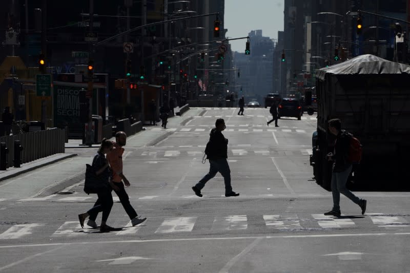 People cross a deserted 7th Ave in Times Square during the outbreak of Coronavirus disease (COVID-19), in the Manhattan borough of New York City