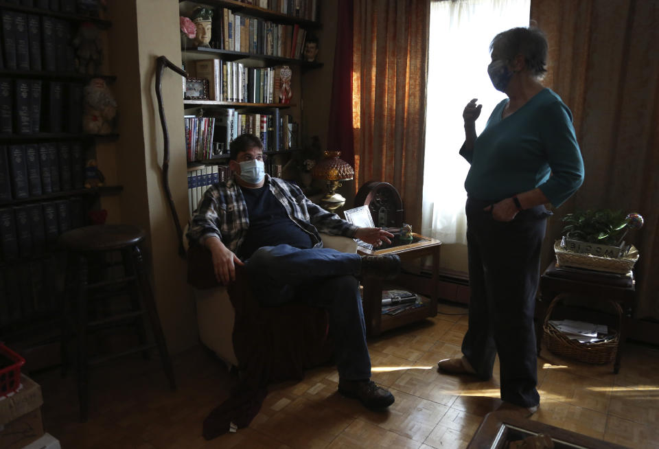 Brian Walter and his mother, Peg Walter, share stories about his late father at their home in the Queens borough of New York, Tuesday, March 30, 2021. John Walter died of the coronavirus May 10, 2020. A year later his son and widow and many others who lost loved ones held a memorial for Queens residents who died from COVID-19. (AP Photo/Jessie Wardarski)