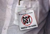 A cloth merchant wears a message pinned to his shirt during a protest against implementation of Goods and Services Tax (GST) on textiles in Kolkata, India, June 28, 2017. REUTERS/Rupak De Chowdhuri