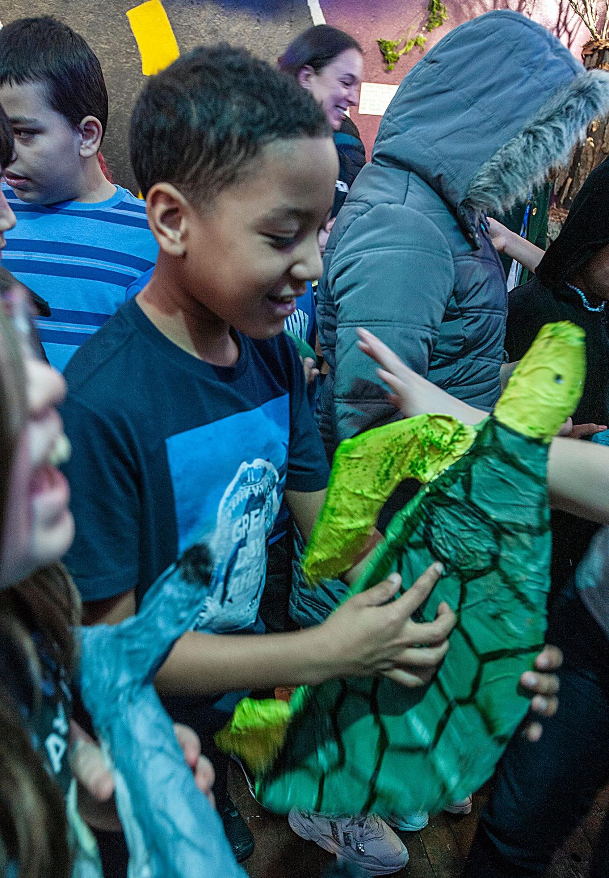 Javen Castro, a fifth grader from the McCarthy Elementary School, explores the Framingham High School Environmental Awareness Club's climate-themed art gallery at the Saxonville Mills, March 12, 2024.