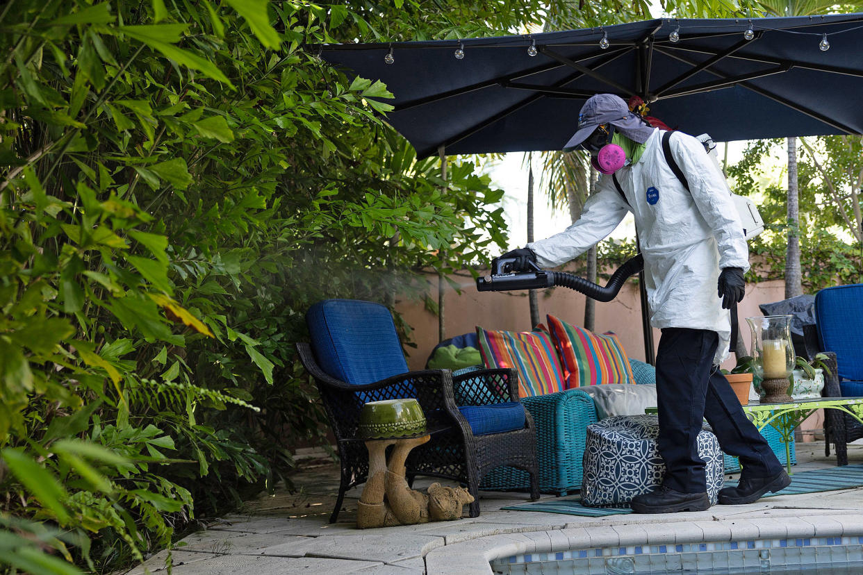 A Miami-Dade Mosquito Control Inspector sprays pesticide to kill adult mosquitos on June 29, 2023. (Joe Raedle / Getty Images)