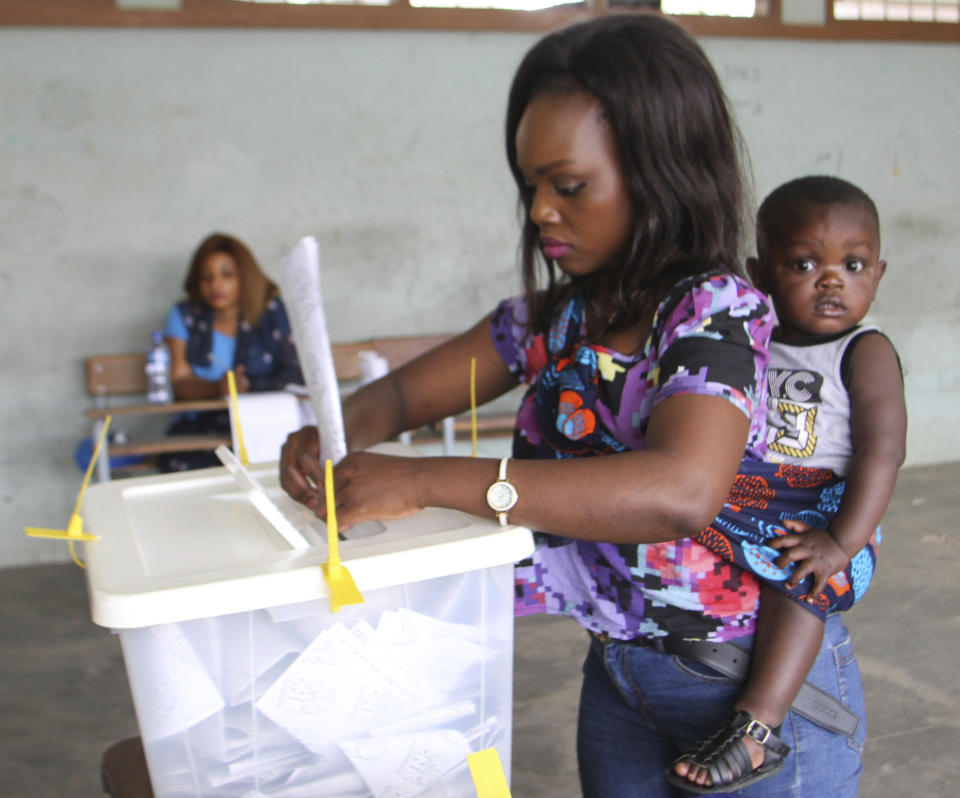 A woman drop her vote into a ballot box in Maputo, Mozambique, Tuesday, Oct. 15, 2019 in the country's presidential, parliamentary and provincial elections. Polling stations opened across the country with 13 million voters registered to cast ballots in elections seen as key to consolidating peace in the southern African nation. (AP Photo/Ferhat Momade)
