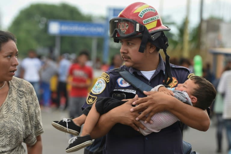 A Guatemalan firefighter carries an ailing baby