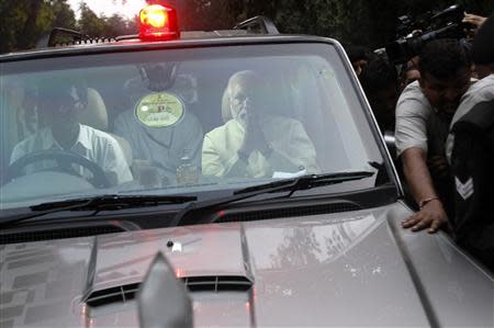 India's Hindu nationalist Narendra Modi (R, in vehicle) greets supporters as he arrives at the headquarters of India's main opposition Bharatiya Janata Party (BJP) in New Delhi September 13, 2013. REUTERS/Anindito Mukherjee