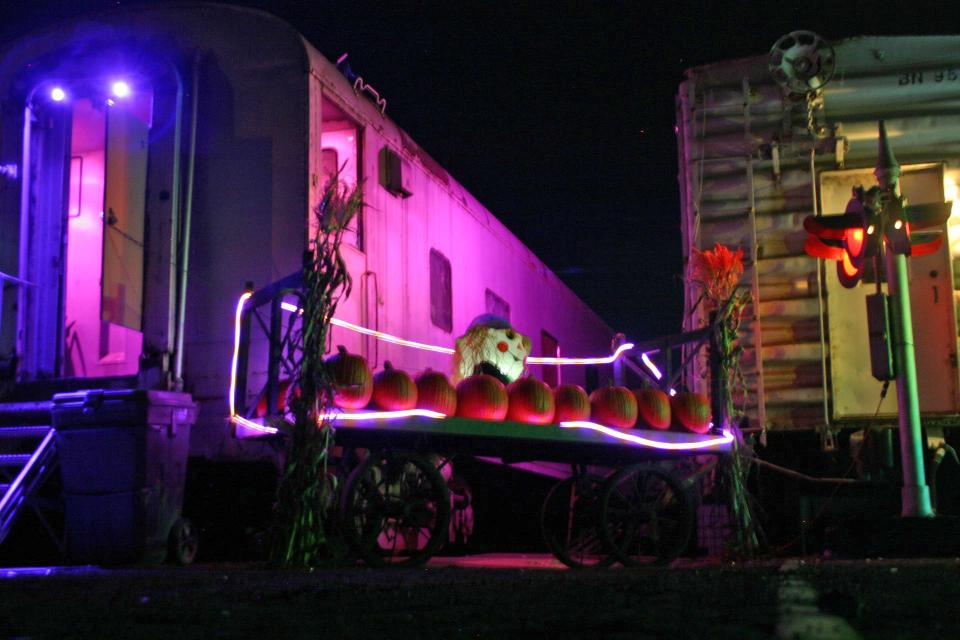 A scarecrow, pumkins and Halloween lights decorate a haunted train car at the Pueblo Railway Museum.