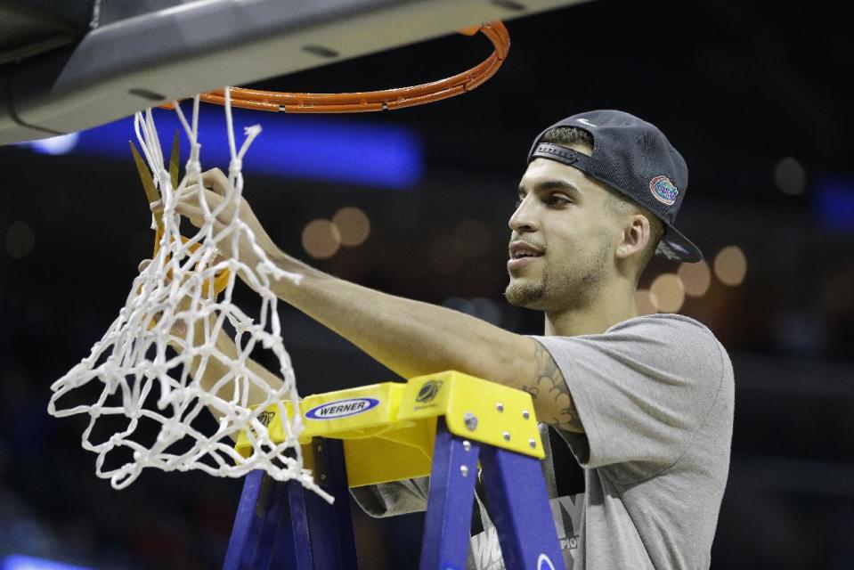 Florida guard Scottie Wilbekin cuts part of the net after the second half in a regional final game against Dayton at the NCAA college basketball tournament, Saturday, March 29, 2014, in Memphis, Tenn. Florida won 62-52. (AP Photo/Mark Humphrey)