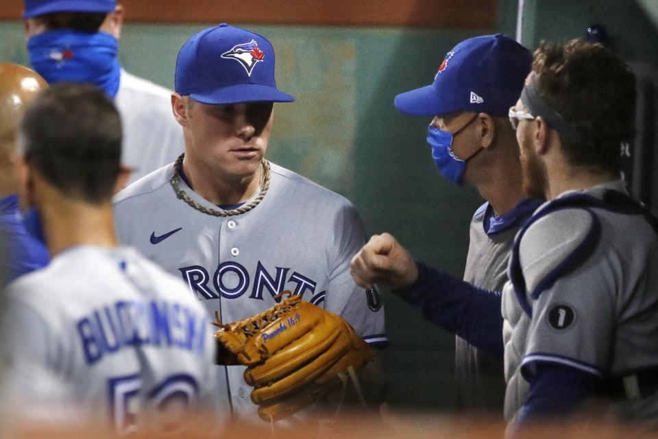 Toronto Blue Jays' Chase Anderson, left, enters the dug out after pitching during the third inning of a baseball game against the Boston Red Sox, Saturday, Aug. 8, 2020, in Boston. (AP Photo/Michael Dwyer)