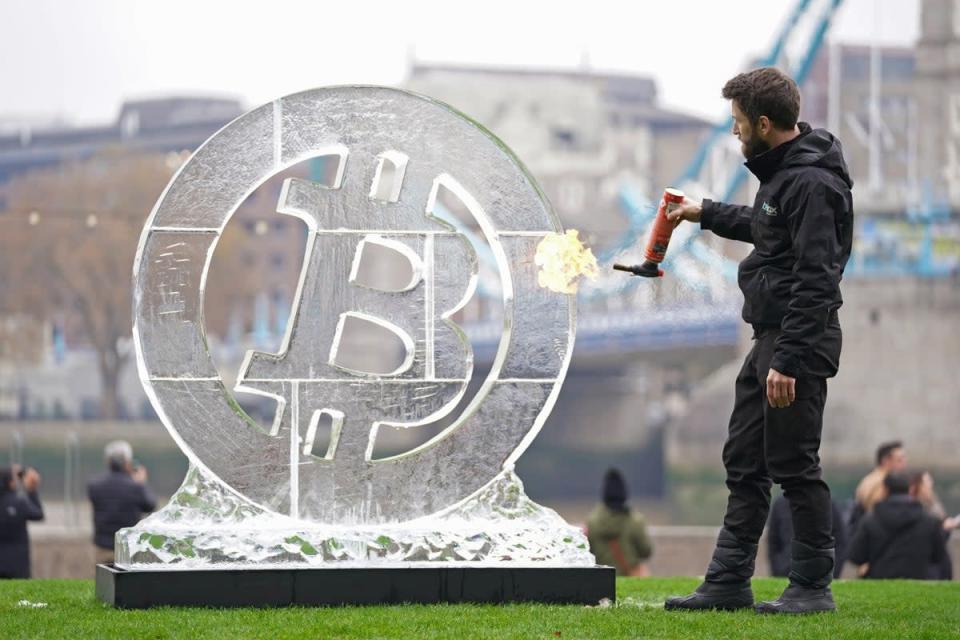 Ice Sculptor Csaba Vass puts the finishing touches to a large Bitcoin ice carving in front of Tower Bridge in London, to celebrate the eighth anniversary of the world’s leading crypto exchange, Huobi Global. Picture date: Wednesday November 24, 2021. (PA Archive)