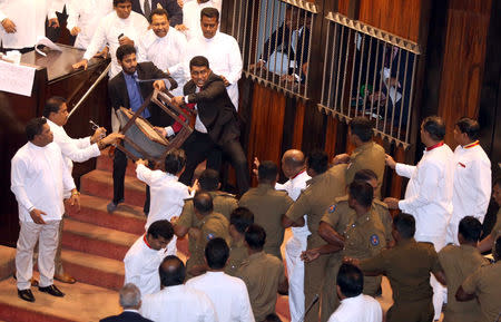 Parliament member Johnston Fernando who is backing newly appointed Prime Minister Mahinda Rajapaksa throws a chair at police who are there to protect parliament speaker Karu Jayasuriya (not pictured) during a parliament session in Colombo, Sri Lanka November 16, 2018. REUTERS/Stringer