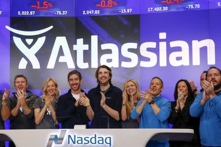 Mike Cannon-Brookes (C), co-founder and CEO of Atlassian Software Systems, and Scott Farquhar (3rd L), co-founder and CEO of Atlassian Software Systems, smile during it's opening PO at the Nasdaq at a MarketSite in New York, December 10, 2015. Atlassian Corporation Plc raised $462 million in its initial public offering in New York on Wednesday, as investors gave the Australian software company a warmer reception versus other stock market hopefuls in the technology sector this year. REUTERS/Shannon Stapleton - GF10000261245