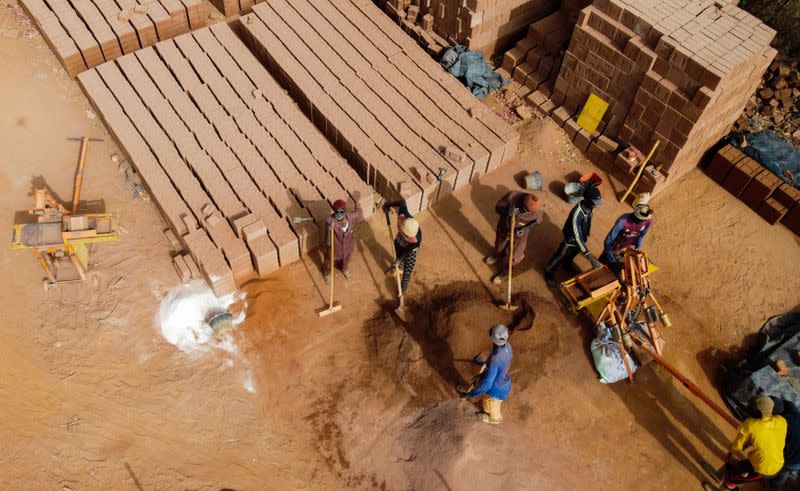 Workers prepare raw soil to make bricks at the Elementerre factory in Mbour