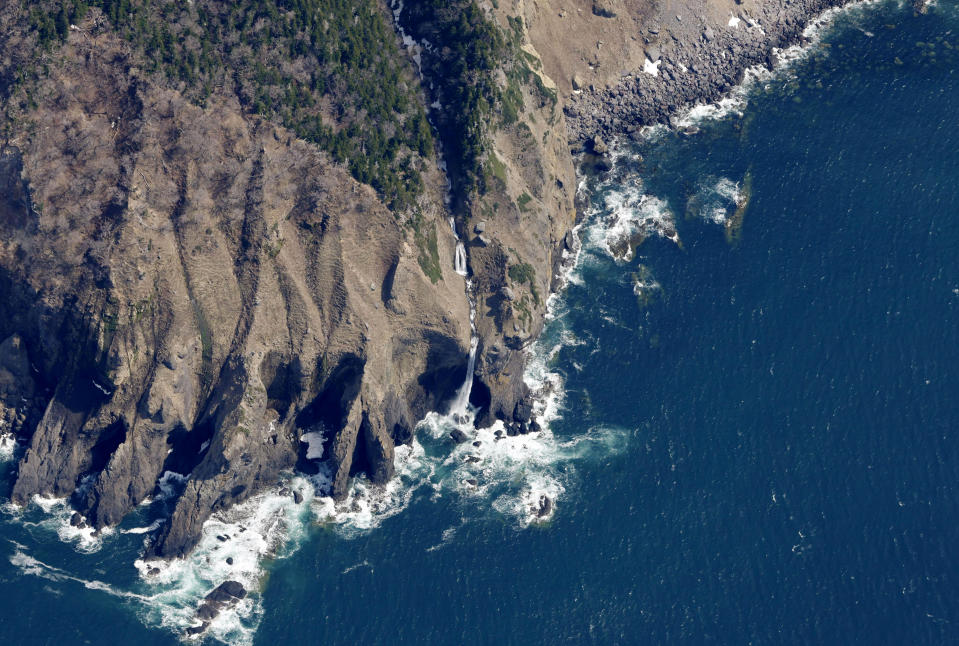 ADDS THE KASHUNI WATERFALL - This aerial photo shows the Kashuni Waterfall, seen at center, near the waters where rescuers continue search for the passengers on a missing tour boat, off Shiretoko Peninsula, Hokkaido, northern Japan Sunday, April 24, 2022. The Japanese Coast Guard said Sunday that rescue helicopters found several of the 26 people from a tour boat missing in the frigid waters of northern Japan since the day before. The location, near the Kashuni Waterfall, is known as a difficult place to maneuver boats because of its rocky coastline and strong tide.(Masanori Takei/Kyodo News via AP)