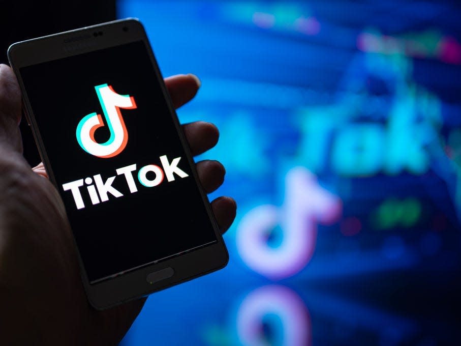 hand holding phone with TikTok logo