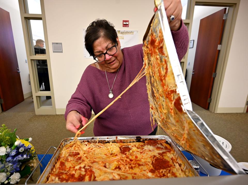 Assistant Clerk-Magistrate Darlene Perro uncovers an especially cheesy lasagna during a staff appreciation luncheon at Worcester Central District Court.